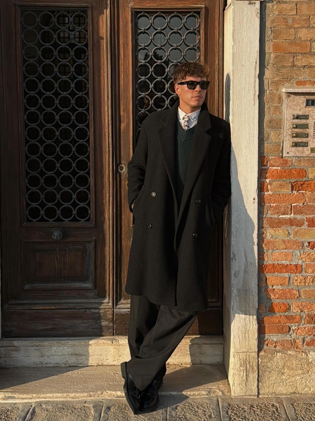 Klodian Mihaj outside a Venetian doorway in a dark coat